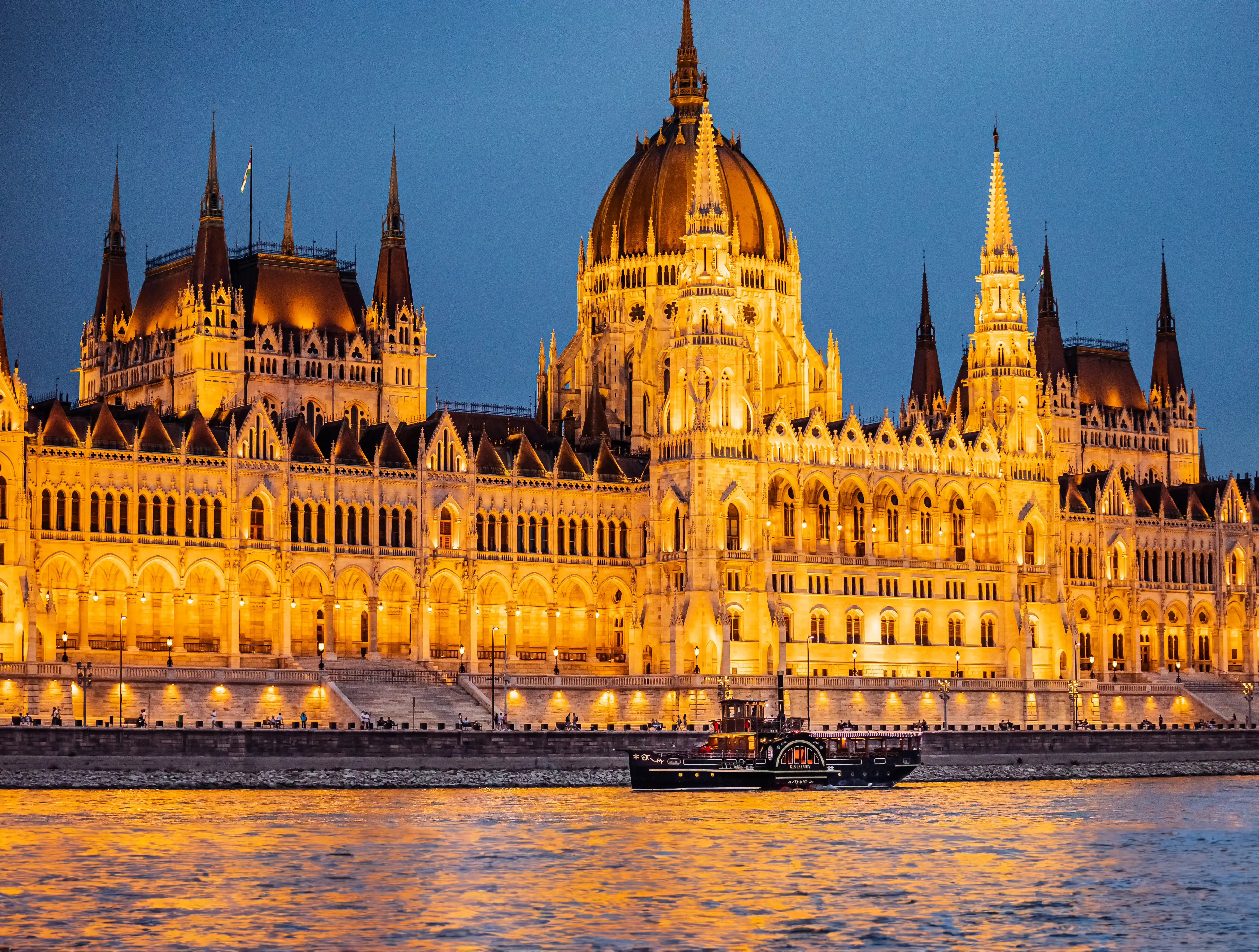 Budapest Danube river cruise at night with the illuminated Hungarian Parliament building in the background