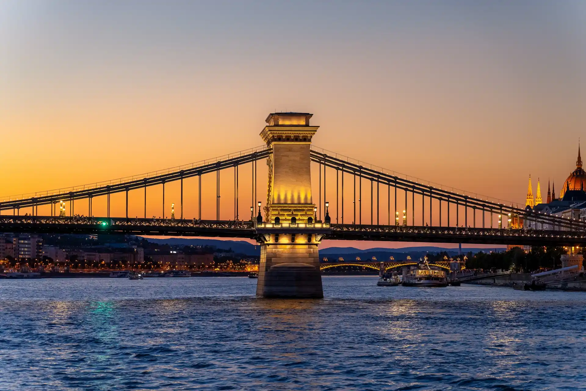 Budapest Danube river cruise at night with the illuminated Hungarian Parliament building in the background